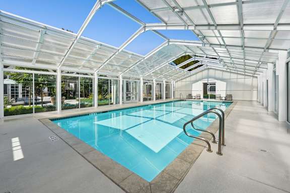 A large indoor swimming pool with a glass ceiling.