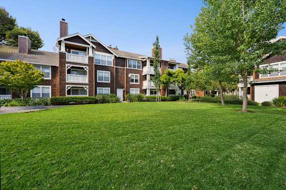 A large grassy area in front of apartment buildings.