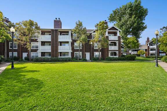 A large grassy area in front of apartment buildings.