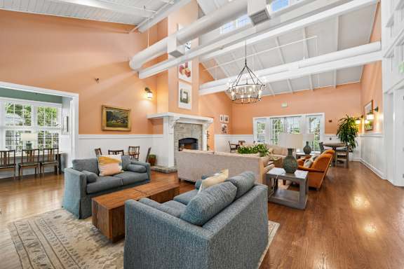 A living room with a grey couch and a fireplace.