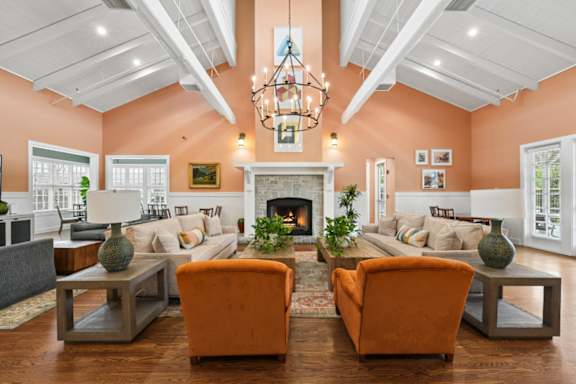 A living room with orange chairs and a fireplace.
