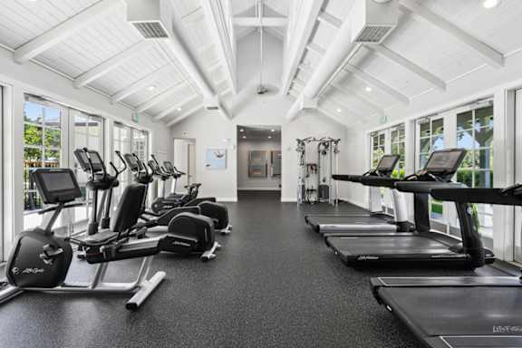A spacious gym with treadmills and elliptical machines.
