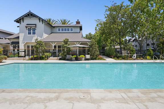 A large house with a pool in front.
