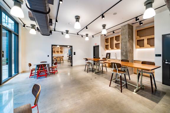 A room with tables and chairs and a concrete floor.