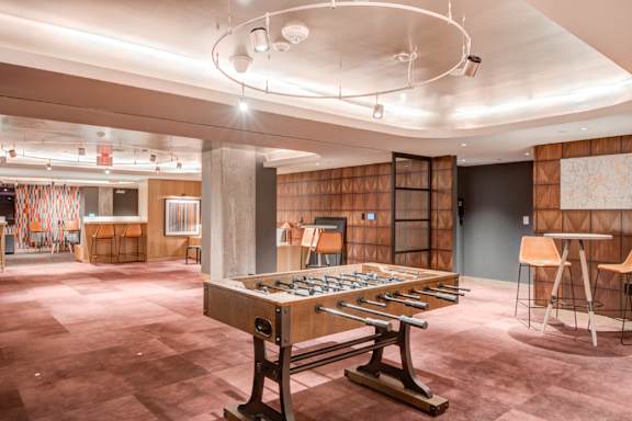 A foosball table is in the middle of a room with a wooden floor.