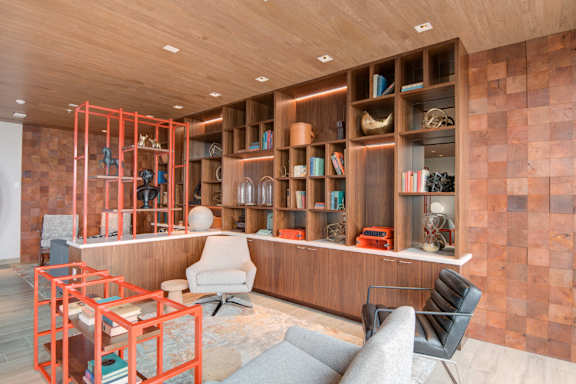 A room with a wooden floor and a bookshelf with books and decorative items.
