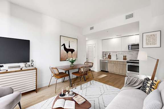 A living room with a grey couch, a wooden coffee table, and a television.