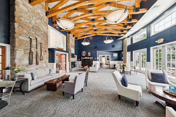 A spacious living room with a stone wall and a large wooden beam ceiling.