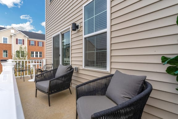 a balcony with two chairs and a table and a window at Brandywine Crossing, Brandywine, MD 20613