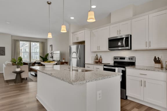 an open kitchen and living room with white cabinets and granite counter tops at Brandywine Crossing, Brandywine, MD 20613