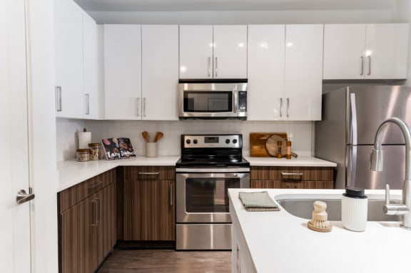 a modern kitchen with stainless steel appliances and white cabinets