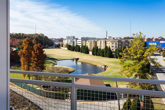 A view from a balcony overlooking a lake and buildings.
