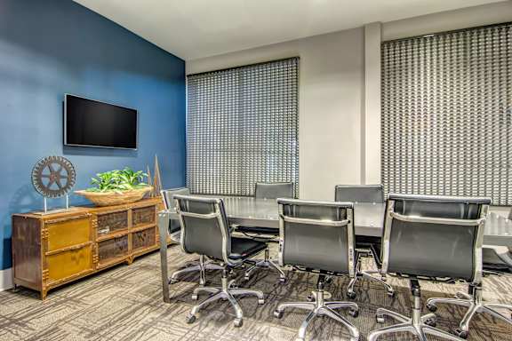 A room with a blue wall and a television mounted on it.