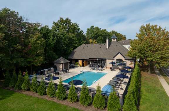 a backyard with a swimming pool and a house with a pool and chairs