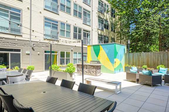 A modern outdoor seating area with a wooden table and chairs.