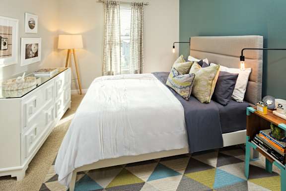 A bedroom with a white bed and a white nightstand.