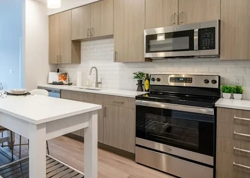 a kitchen with stainless steel appliances and a white table