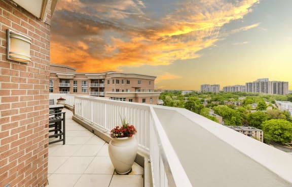 a balcony with a view of the city at sunset