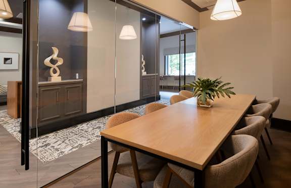 A conference room with a long table and chairs.