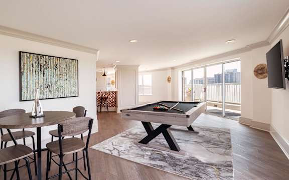 A room with a pool table and a painting on the wall.