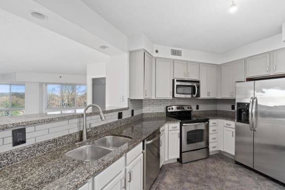 a kitchen with granite counter tops and stainless steel appliances