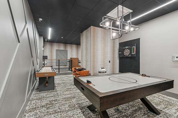A room with a pool table and a dartboard.