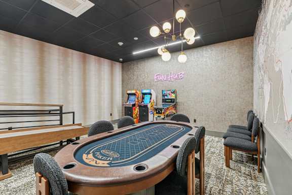 A poker table is in the middle of a room with a sign that says Fun Hub.