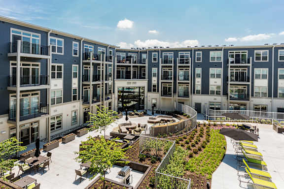 A courtyard surrounded by apartment buildings with a fountain in the middle.