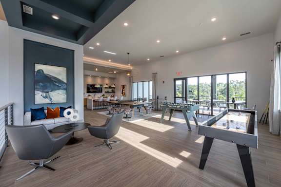 Clubhouse game room with shuffleboard, ping pong, and seating