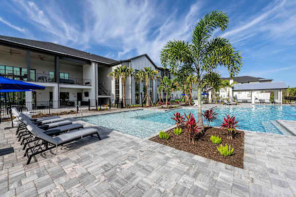 Resident pool with outdoor seating at The Crossing at Palm Aire
