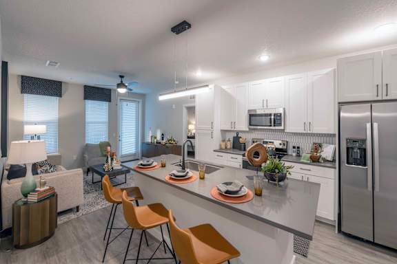 A modern kitchen with white cabinets and a large island.