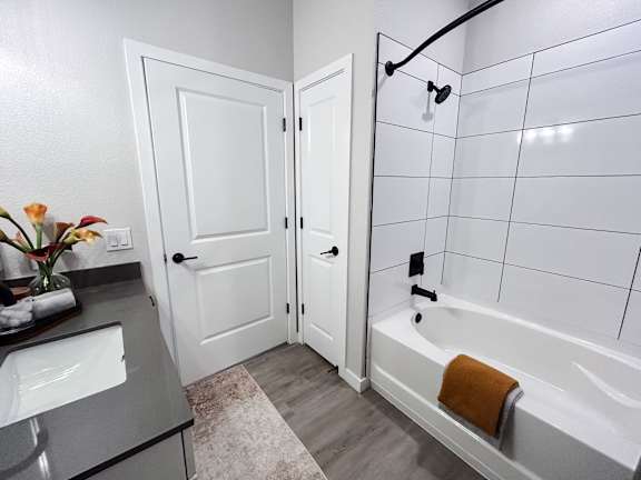 A white bathroom with a white tub and a white door.