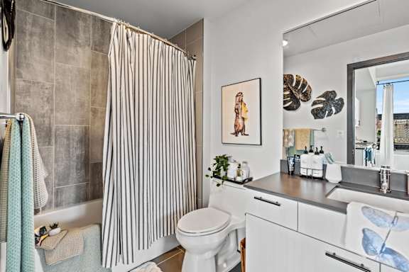 A bathroom with a toilet, sink, and shower curtain.