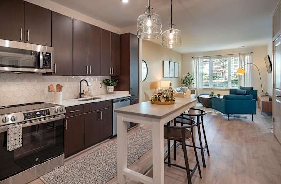 A modern kitchen with dark brown cabinets and a white island.