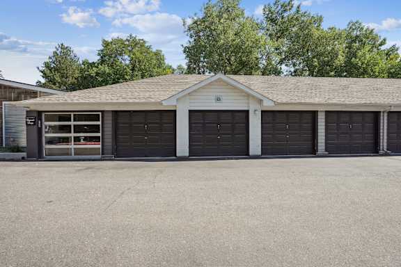A building with a grey roof and black garage doors.