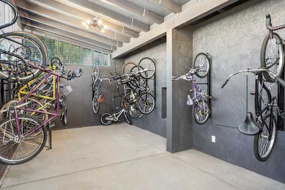 A bike room with many bikes hanging on the wall.