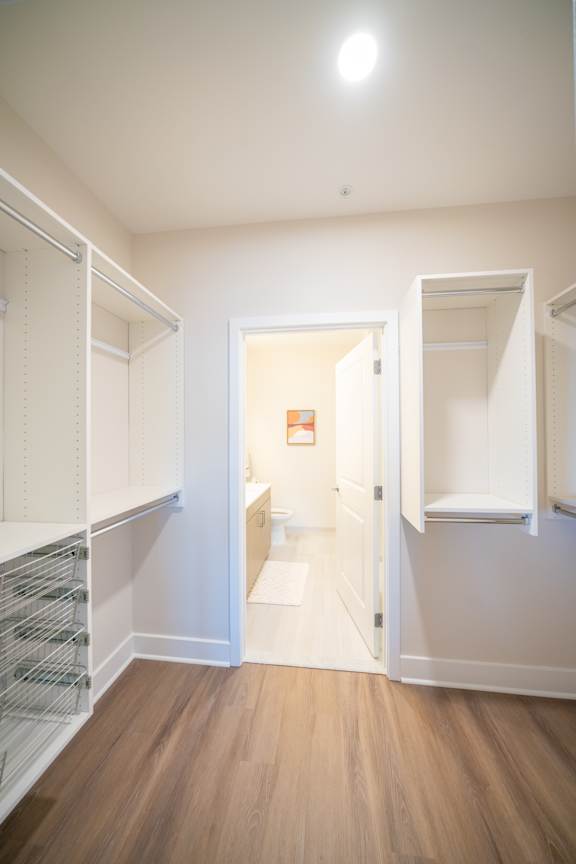 A white pantry with a doorway leading to a hallway.
