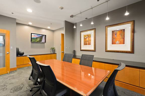 A conference room with a long table and chairs.