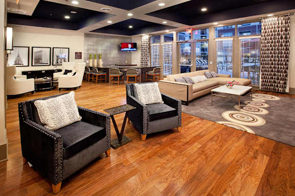 A living room with a black chair and a white chair with a cushion.