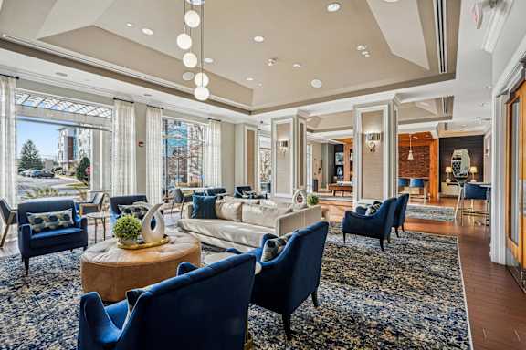 A living room with blue chairs and a wooden coffee table.