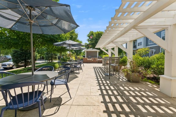a patio with tables and chairs and umbrellas