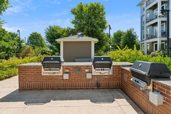 a brick wall with three barbecue grills on it