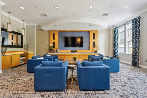 a living room with blue chairs and a television