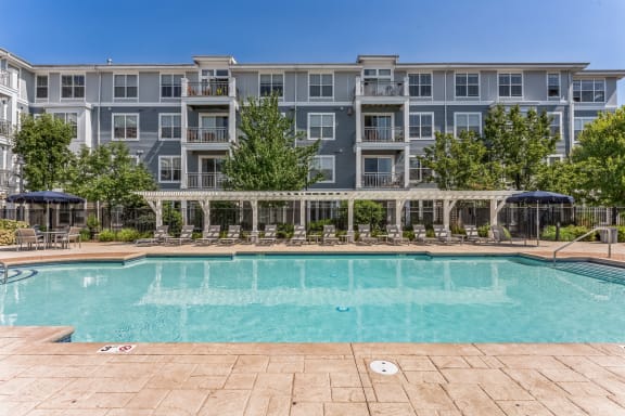 a swimming pool with an apartment building in the background