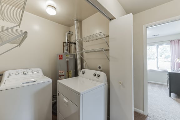 a washer and dryer in a laundry room with a closet and a window