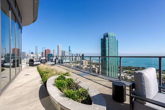 A balcony with a view of the cityscape and the ocean.