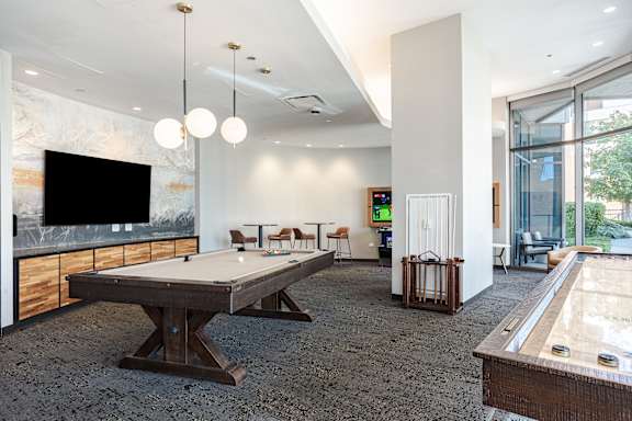 A room with a pool table and a tv.