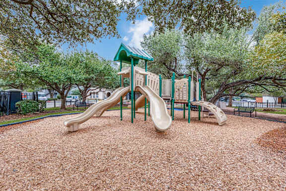 A playground with a green roof and a slide.