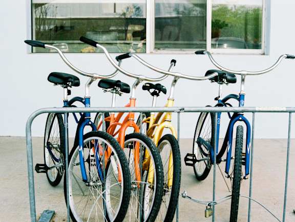A row of bicycles are parked in a bike rack.
