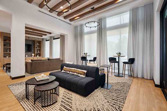 A modern living room with a black sofa and a coffee table.